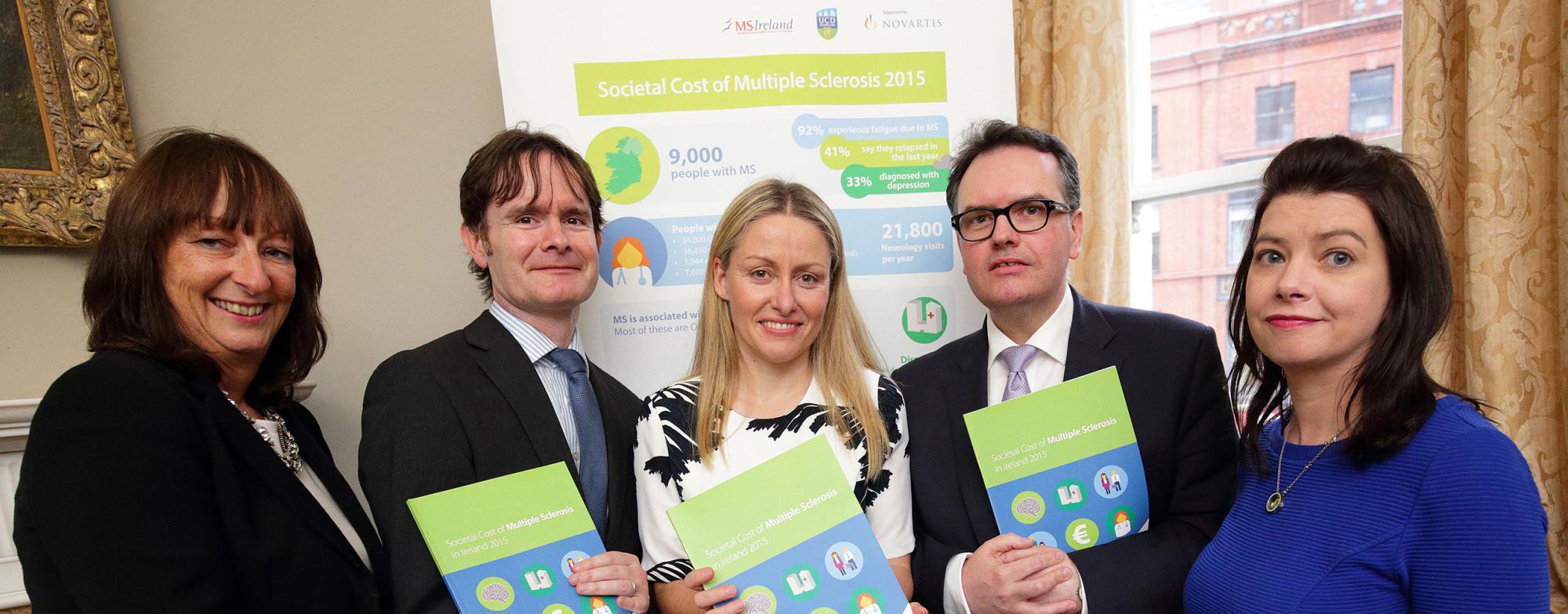 Five people standing together, each holding a copy of the new 'Societal Cost of MS' booklet