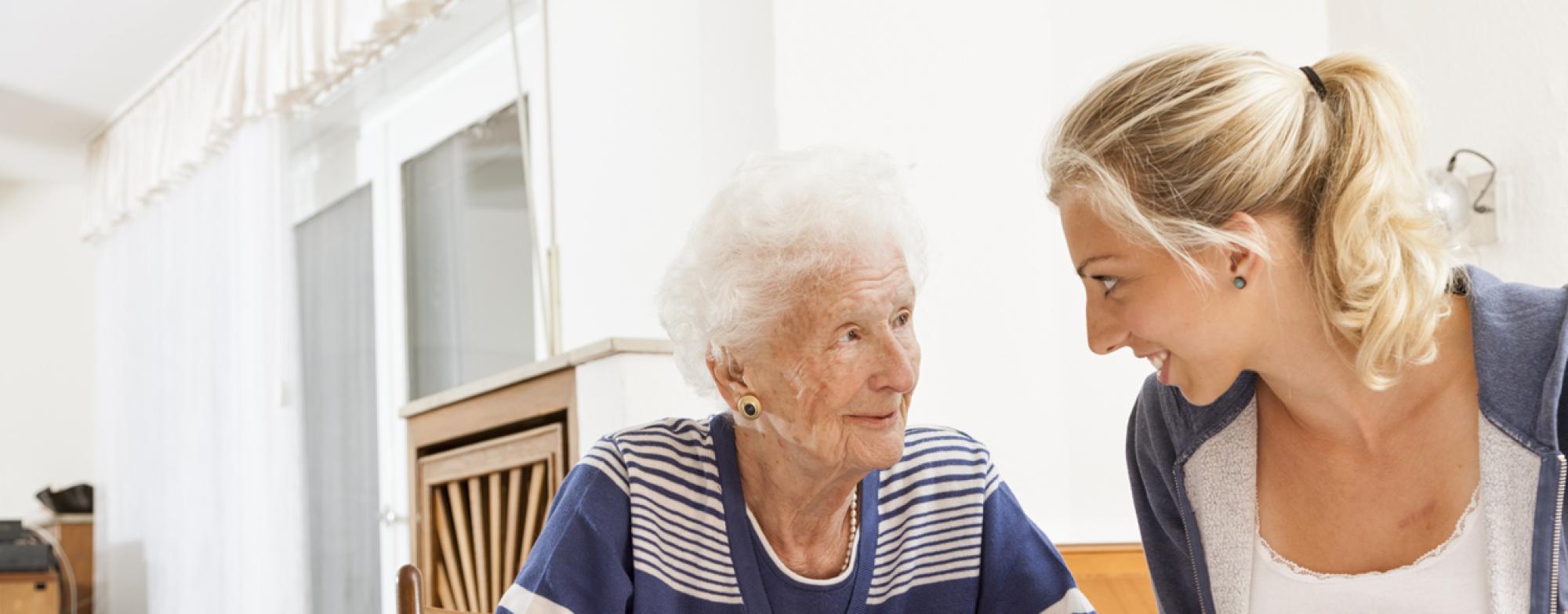 Two people are seated at a table. One of them is holding a pen