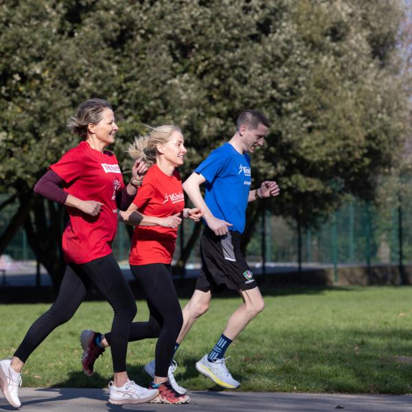 People taking part in a community walk/run event in a park for World MS Day.