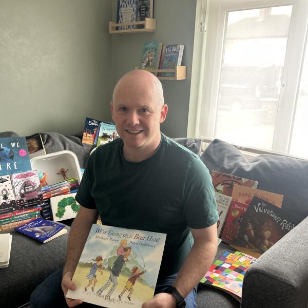 Keith Byrne, MS Readathon ambassador, surrounded by children's books.