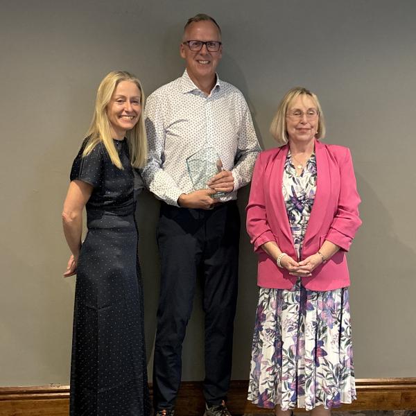 Stephen, MS Ireland's 2026 Volunteer of the Year, holding his award alongside two women at the awards ceremony.