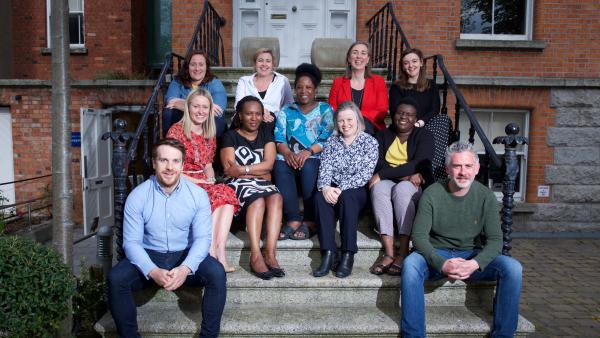 MS Ireland staff sitting on the steps outside the National Office, smiling and posing for a group photo