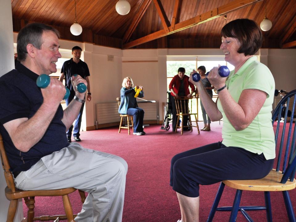 Two people engaging in seated physiotherapy