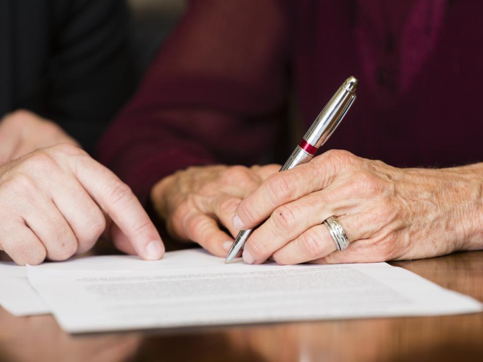 Two people reviewing a will and discussing legacy giving to MS Ireland