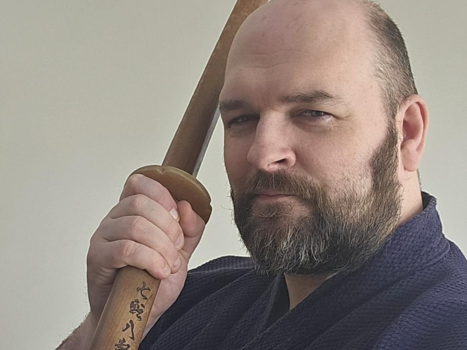Paul holding a wooden martial arts training sword (bokutō)