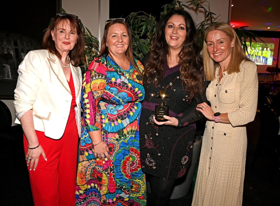 Four people standing together at the MS Ireland Annual Awards 2025 gala dinner, with the award winner holding a trophy