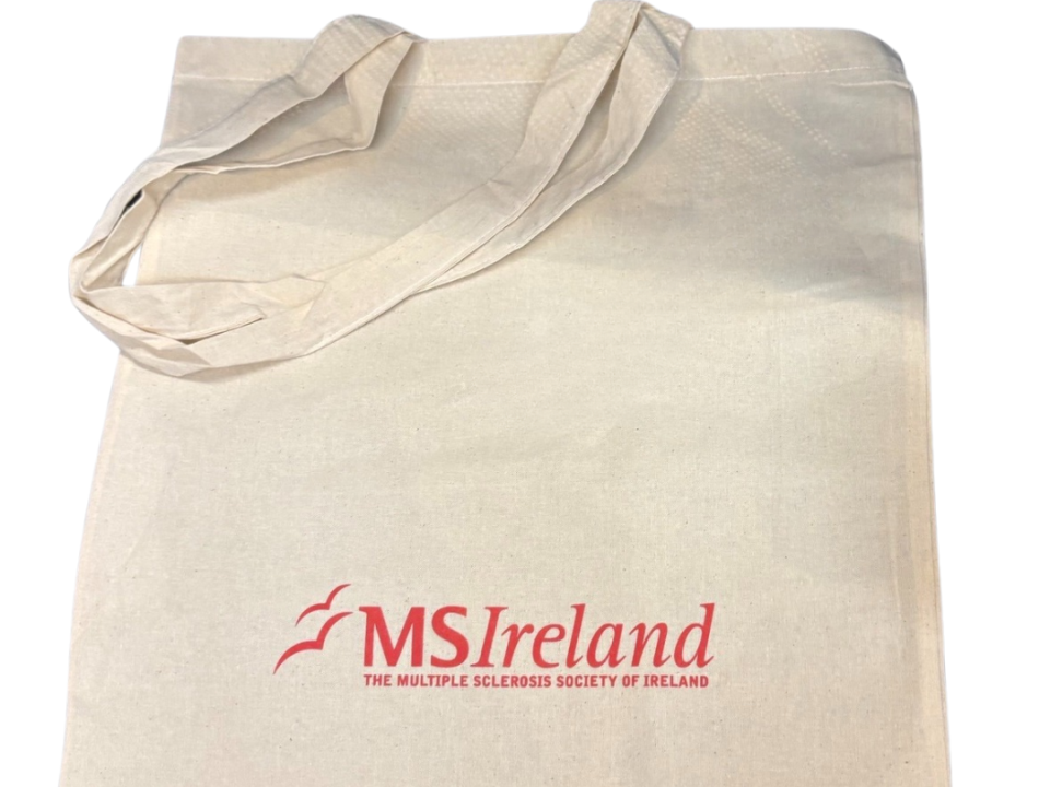 Cream-colored canvas tote bag with long handles, printed with the red ‘MS Ireland’ logo and the text ‘The Multiple Sclerosis Society of Ireland’ on the front, shown against a white background.