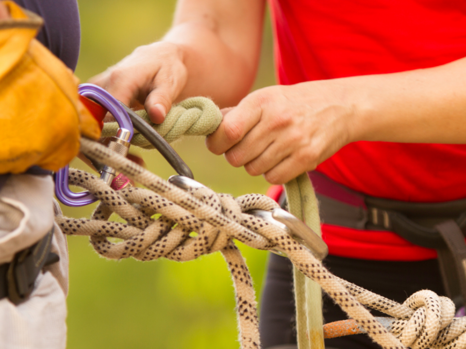 Two people preparing ropes for abseiling