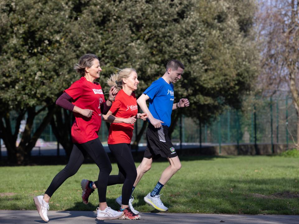 People taking part in a community walk/run event in a park for World MS Day.
