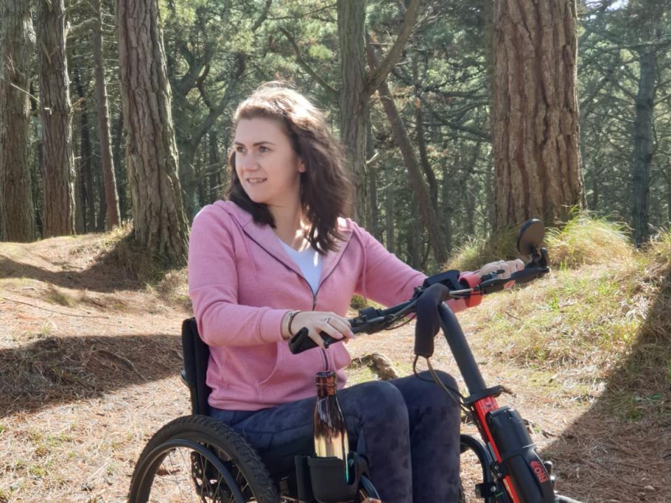 World MS Day ambassador Niamh Redmond outdoors using a powered wheelchair
