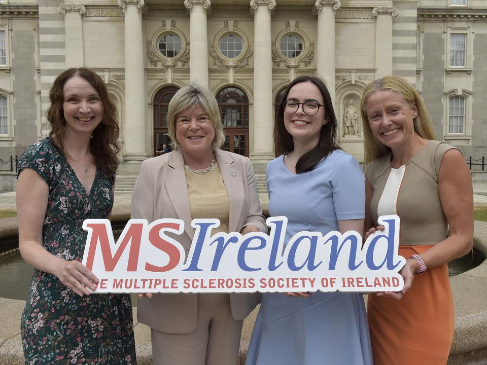 Representatives of the PROMISE Research Project stand outside a government building holding an MS Ireland sign.