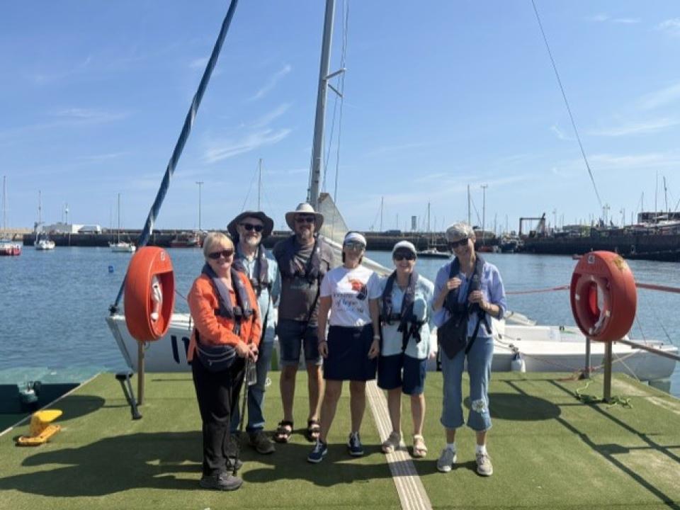 Participants standing near a sailing boat during the 2026 Sailing Programme