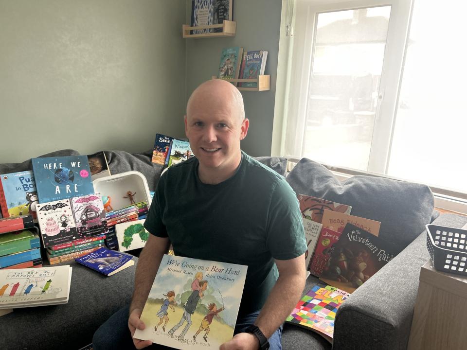 Keith Byrne, MS Readathon ambassador, surrounded by children's books.