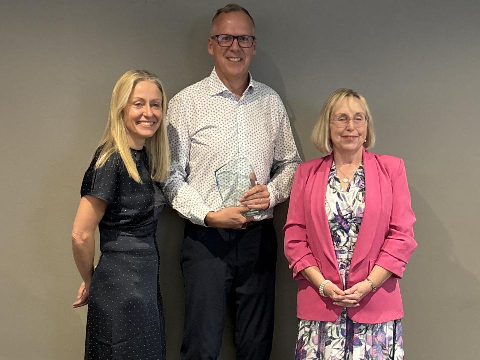 Stephen, MS Ireland's 2026 Volunteer of the Year, holding his award alongside two women at the awards ceremony.