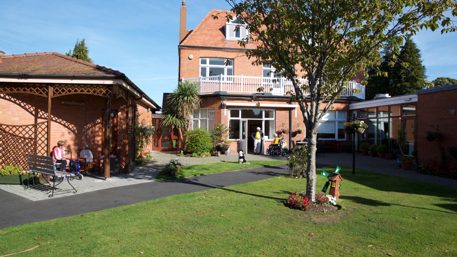 MS Care Centre building with a garden and trees, offering a peaceful outdoor space