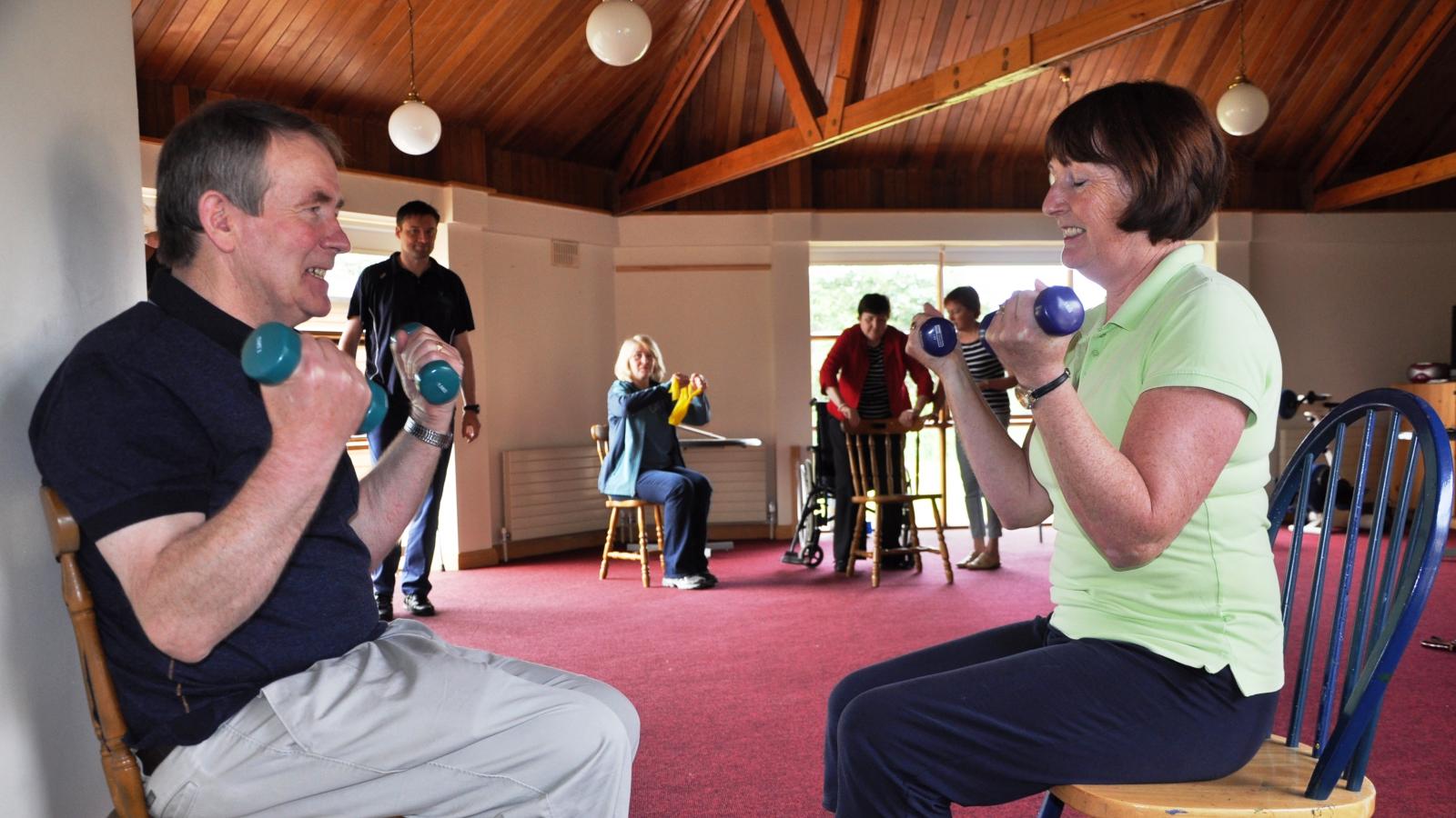 Two people engaging in seated physiotherapy