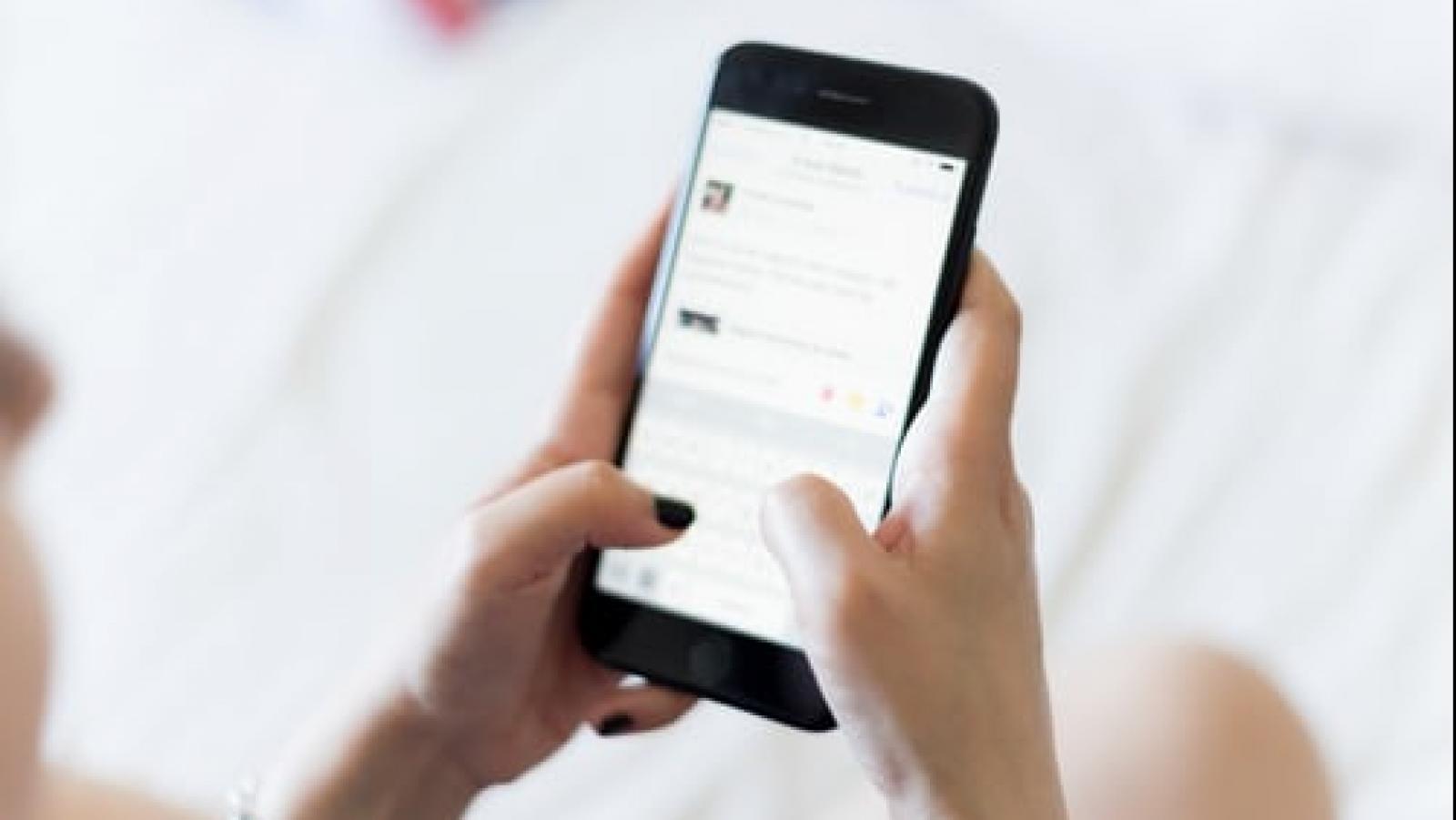 Two hands holding a smartphone with an active screen pointed towards the person.