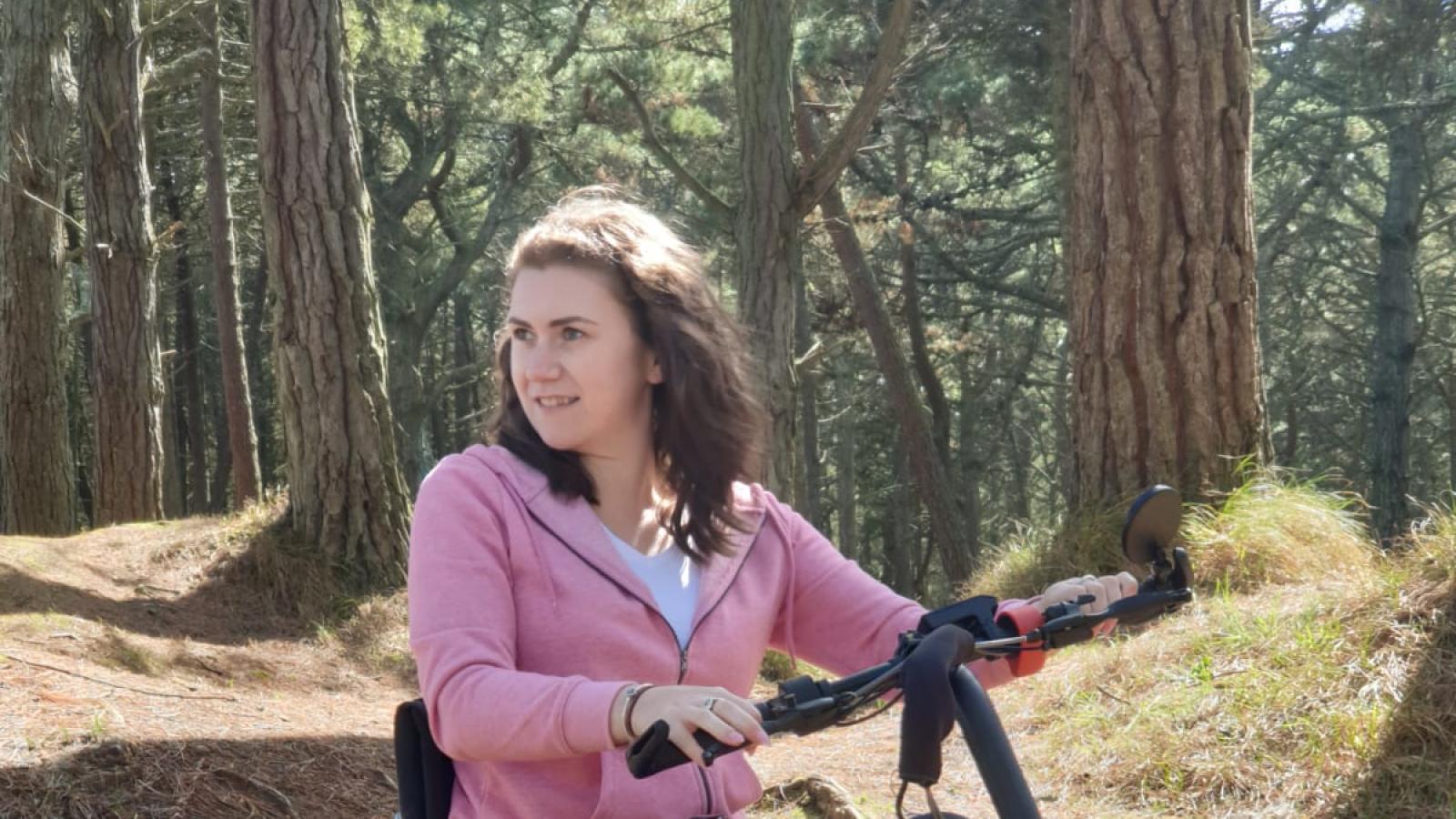 World MS Day ambassador Niamh Redmond outdoors using a powered wheelchair